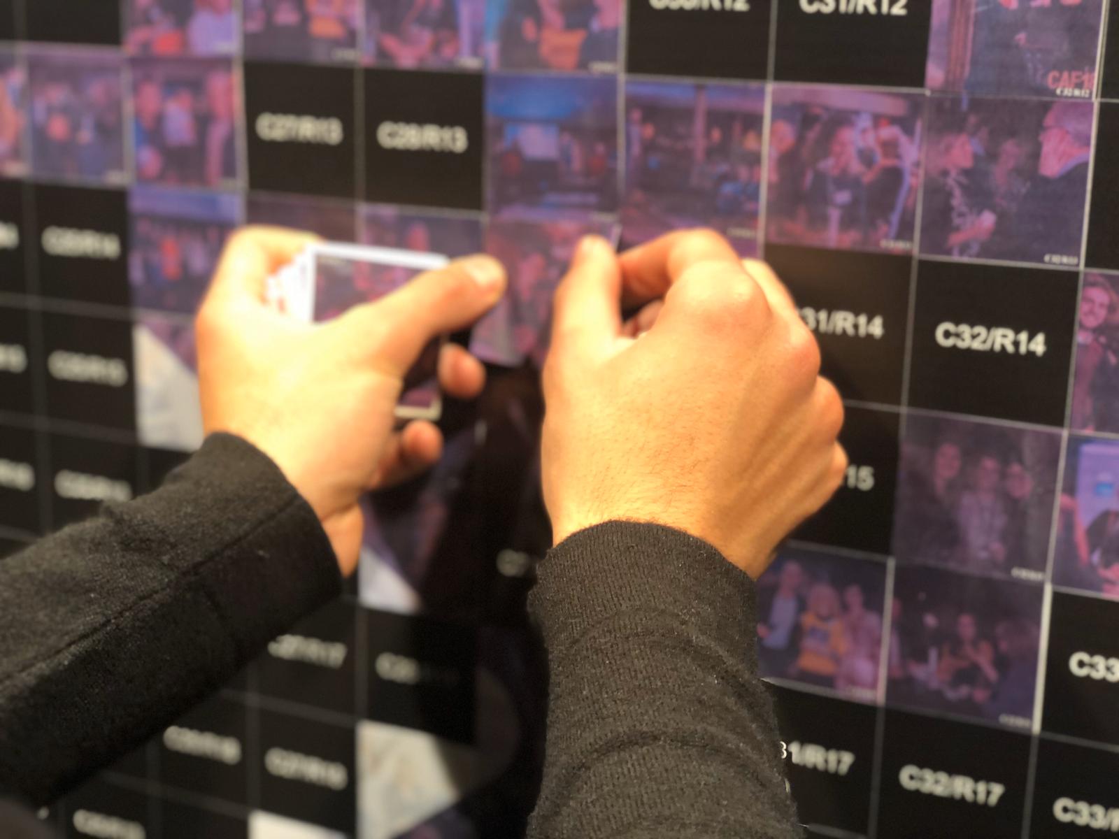 Handen plakken een sticker op de PixlWall